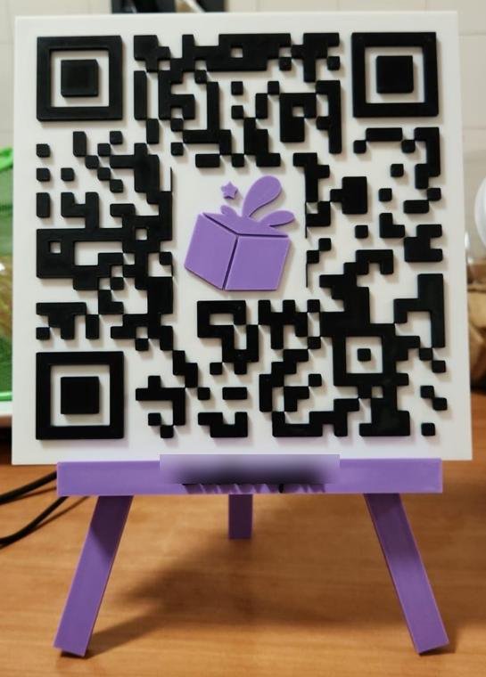 Placa QR impresa en 3D a dos colores, con logo al centro y caballete morado, hecha por MonoLabs3D
